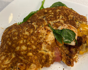 Cooked omelet with spinach and tomatoes